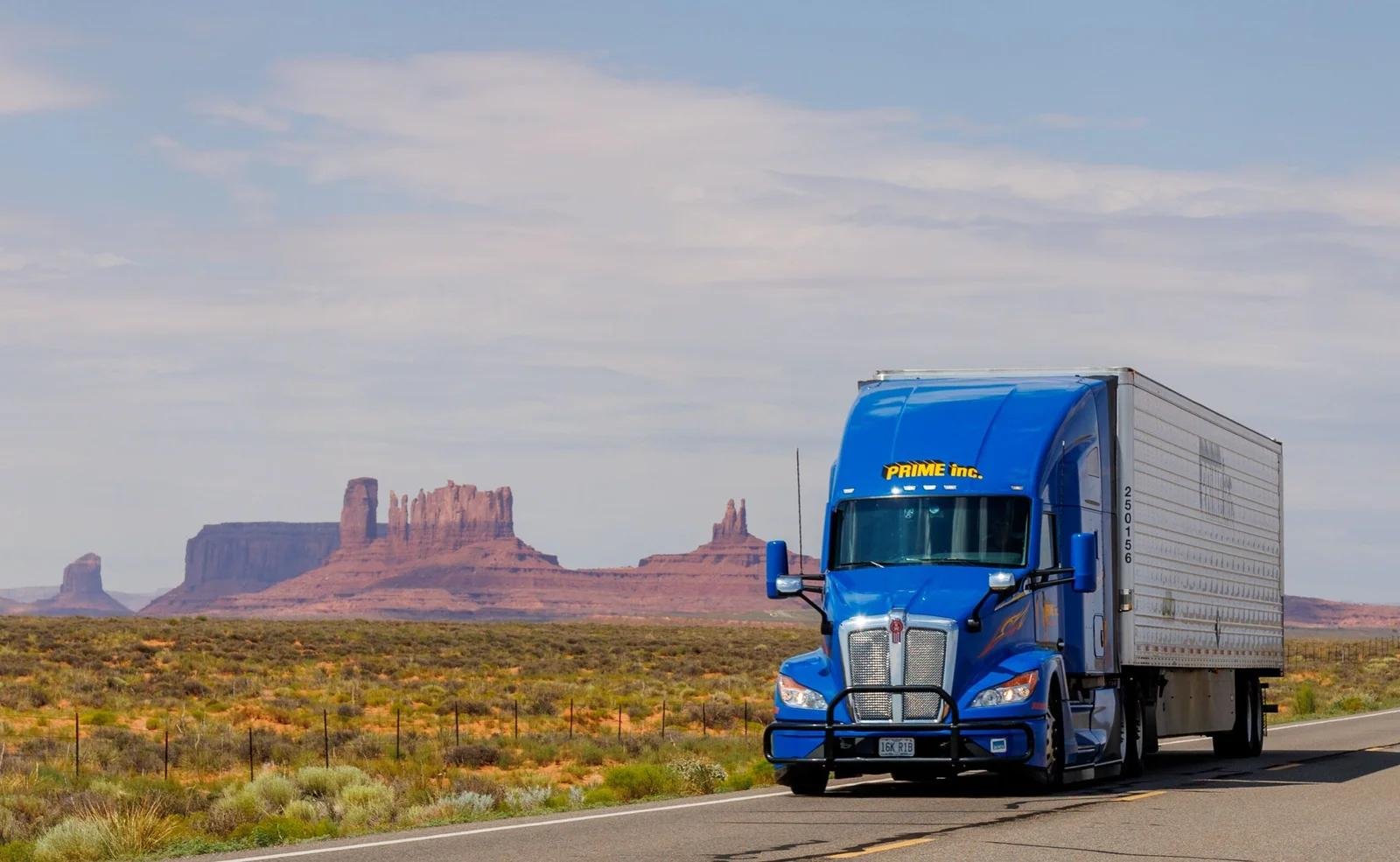 Semi-truck driving past Monument Valley, representing a US trucking company website