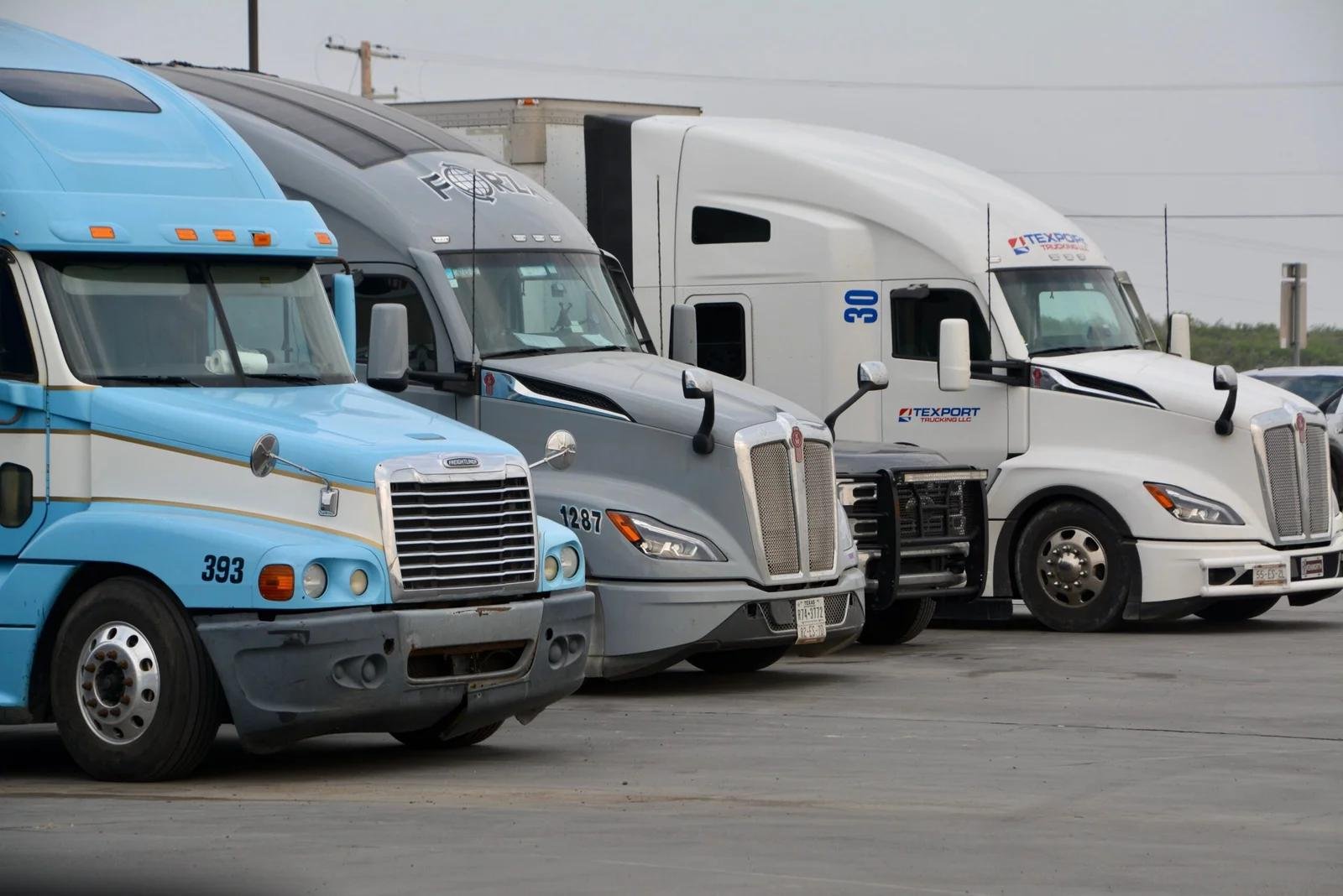 Row of carrier semi-trucks at a US truck stop, representing Orynlo client fleets